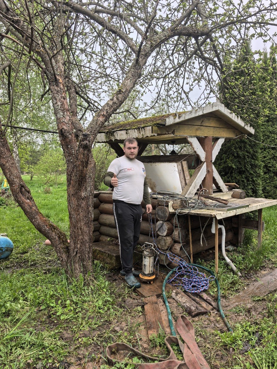 Колодец с деревянным домиком на дачном участке после обслуживания